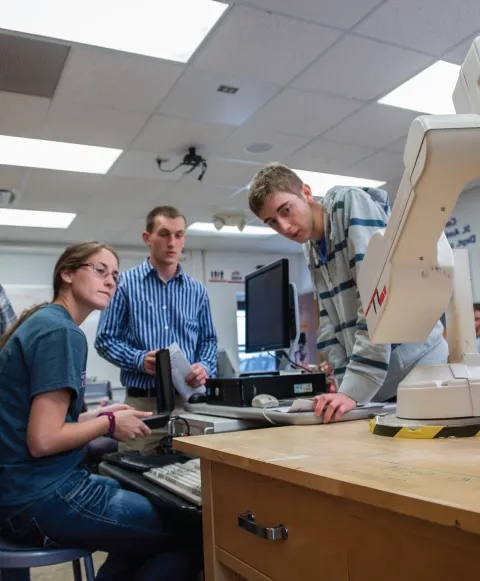 Group of engineering students collaborating on a project in a lab.