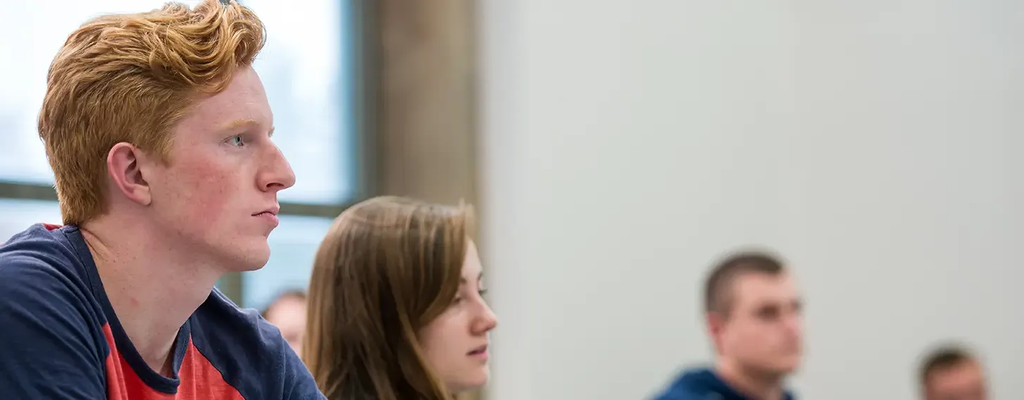 Students in a classroom, focusing on learning.